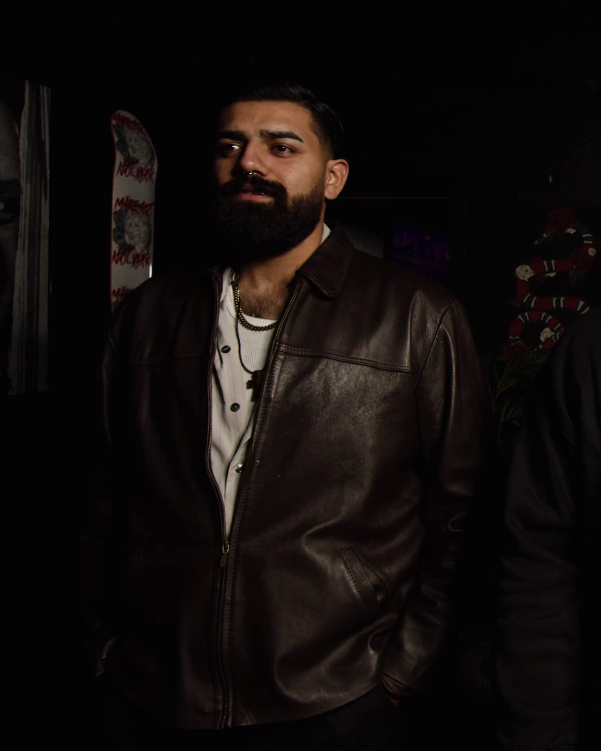 Tali standing in the studio in a leather jacket.